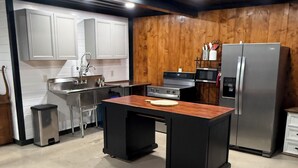 A kitchen with a central island, stainless steel appliances, and wooden paneling. - Lake house minutes from the boat dock w/attached garage for boats or vehicles (Foss)