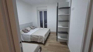 A bedroom with a bed, a wardrobe, and a window. - 15 minutes from Taormina, 20 meters from the sea: La Casa di Lucio - I Pupi Apartment (Nizza di Sicilia)