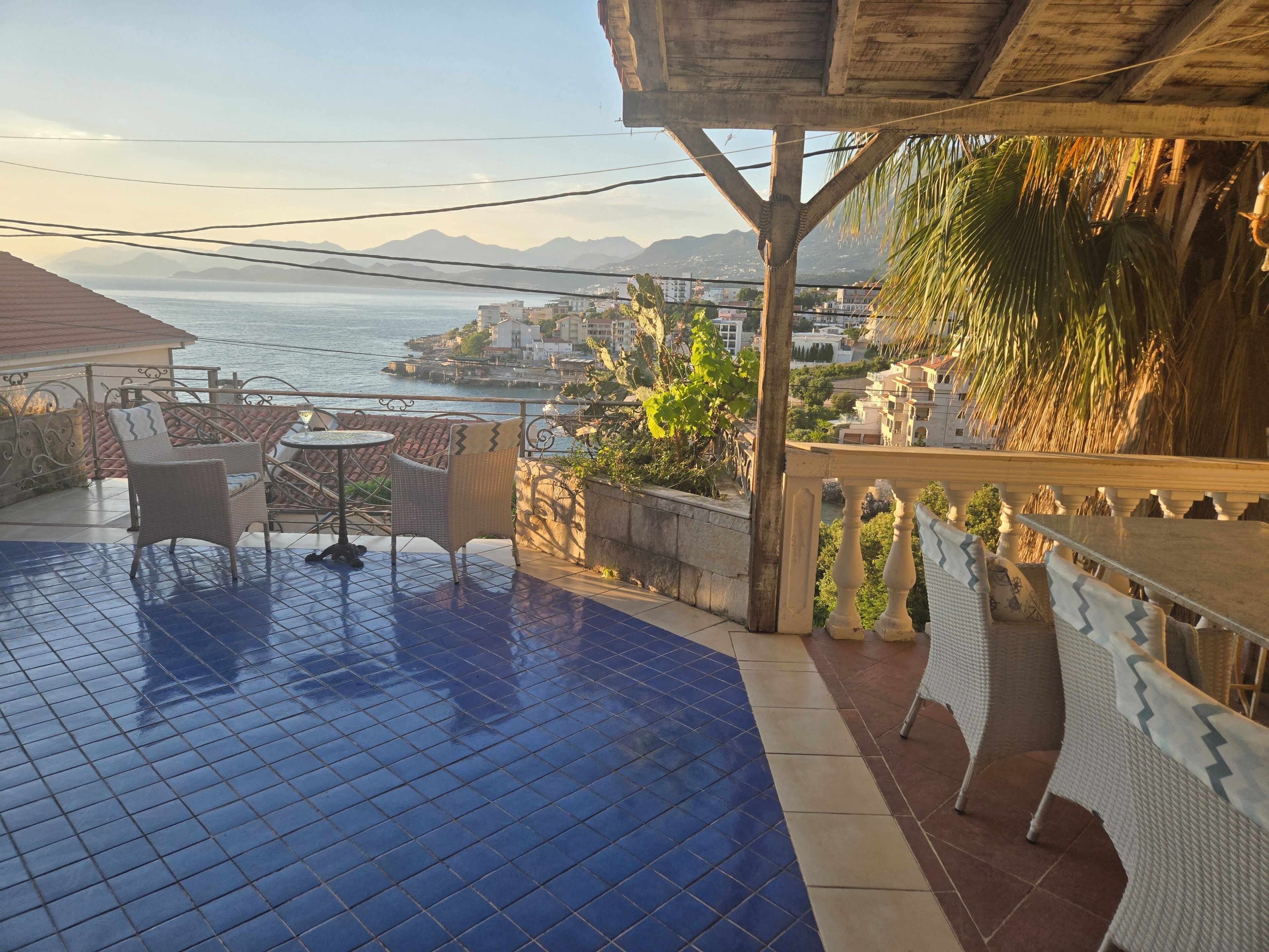 Une terrasse avec vue sur la mer, un sol carrelé et du mobilier d’extérieur.