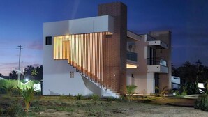 A modern building with a staircase, a flat roof, and a brick section.