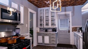 A kitchen with a stove, microwave, cabinets, and a refrigerator. - Spacious 4BR Home Near Niagara Falls State Park | Sleeps 10 | Pet-Friendly (Niagara Falls)