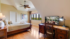 A bedroom with a bed, desk, chair, and a ceiling fan. - Charming pool home in Sea Oats, Sanibel Island (Sanibel)