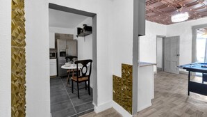 Un interior moderno con comedor, cocina y mesa de billar.