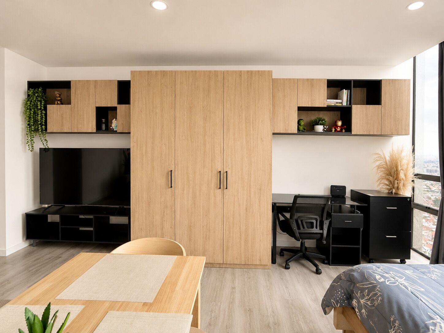 Ein modernes Schlafzimmer mit Bett, Schreibtisch und Fernseher.