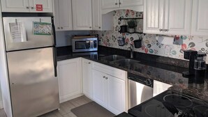 A kitchen with white cabinets, a microwave, a dishwasher, and a stove.