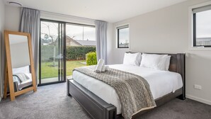 Une chambre à coucher avec un lit, un miroir, une fenêtre et une vue sur l’extérieur.
