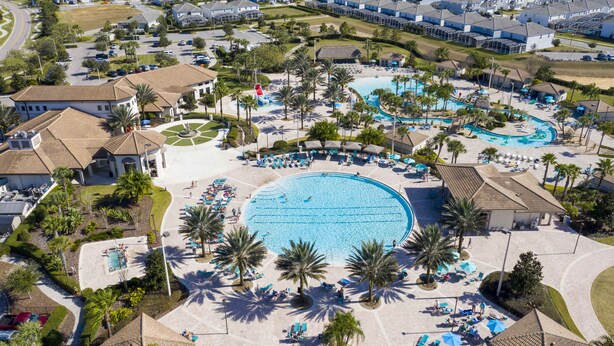 Luchtbeeld van een resort met een groot centraal zwembad, diverse kleinere zwembaden en vele ligbedden en parasols.