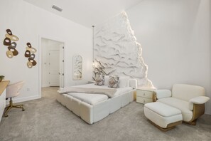 Ein Schlafzimmer mit Bett, Sofa, Schreibtisch und Stuhl.