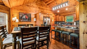 A wooden interior with a dining area, kitchen, and bar.