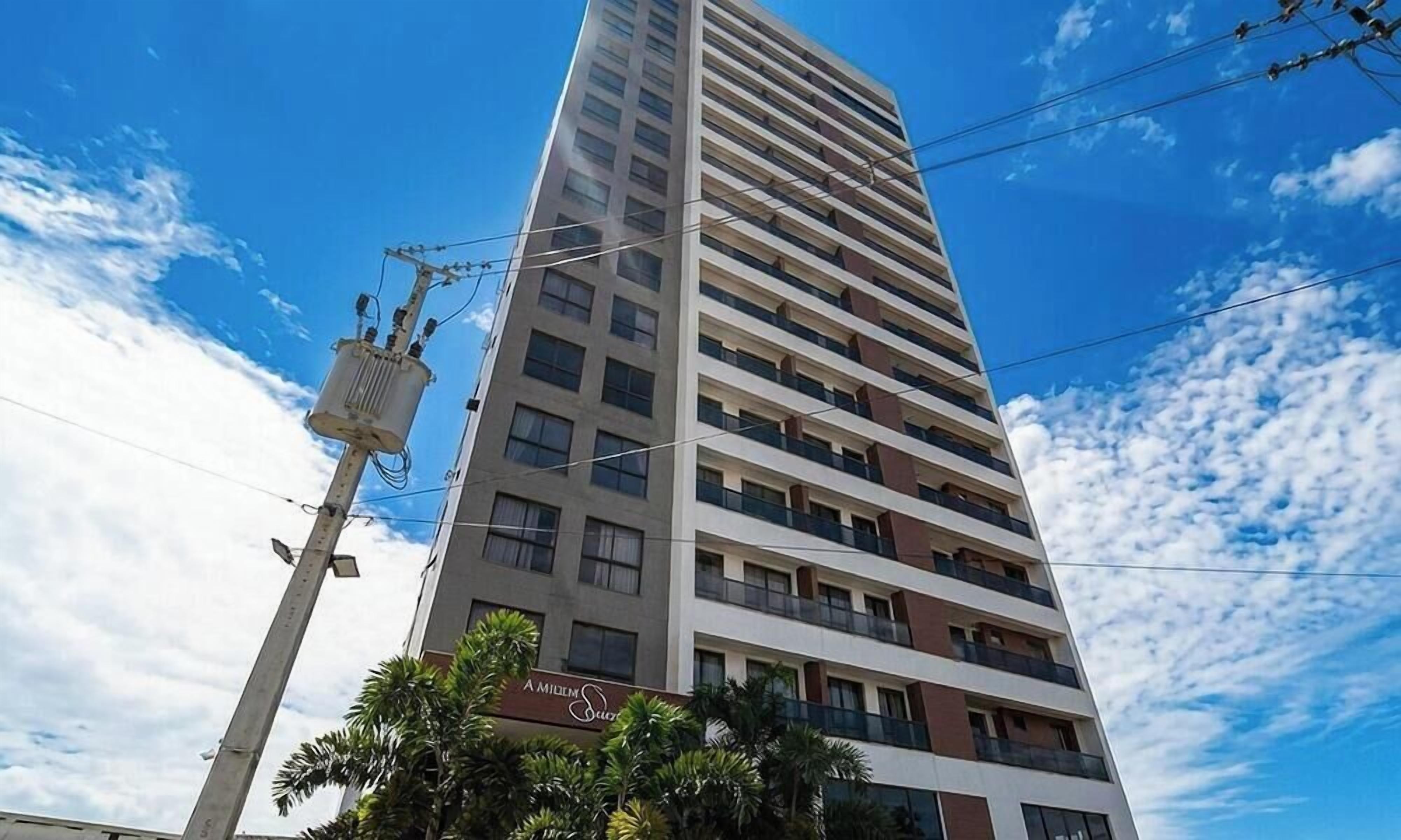 Um hotel com vários andares, céu claro e linhas de eletricidade.