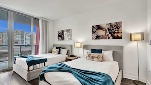 A hotel room with two beds, a large window with a view of buildings, and artwork on the walls. - Inviting Waterfront Stay | Near Ocean & Resort Perks (Hallandale Beach)