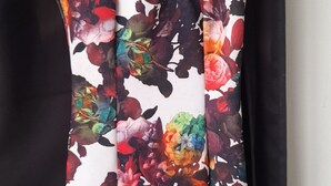 Un vestit amb flors penjat en una perxa.