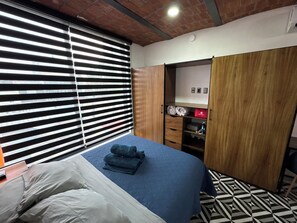 A hotel room with a bed, a wardrobe, and a shelf with toiletries. - Apt in Guadalajara Americana / Downtown • SuperFast Wifi • Walking rate 100% (Guadalajara)