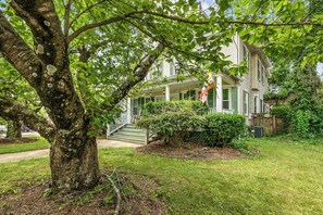 A two-story house with a front porch, a tree in the foreground, and a well-maintained lawn. - Historic Annapolis Home  Walk to Downtown  3BR (Annapolis)