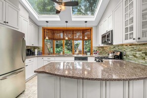 A modern kitchen with a large island, stainless steel appliances, and a skylight. - Historic Annapolis Home  Walk to Downtown  3BR (Annapolis)