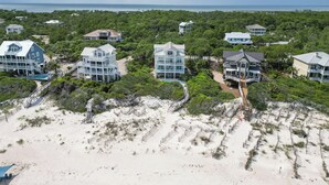 Um resort costeiro com propriedades em frente ao mar, uma praia de areia e vista clara do oceano.