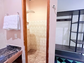 Un baño con ducha, toallero y suelo de mármol.