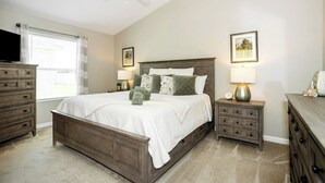 A bedroom with a bed, nightstands, a dresser, a ceiling fan, and two wall-mounted lamps. - WELCOME TO YOUR PIECE OF PARADISE (The Villages)
