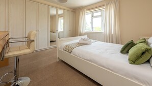 A bedroom with a bed, a chair, a wardrobe, and a window. - Budget-Friendly Group Stay in Newport - Pass the Keys (Newport)