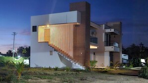 Un edificio moderno con fachada blanca, sección de ladrillo y una escalera.