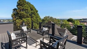 A rooftop deck with outdoor furniture and a view of the city. - Capitol Hill private terrace & mountain views (Seattle)