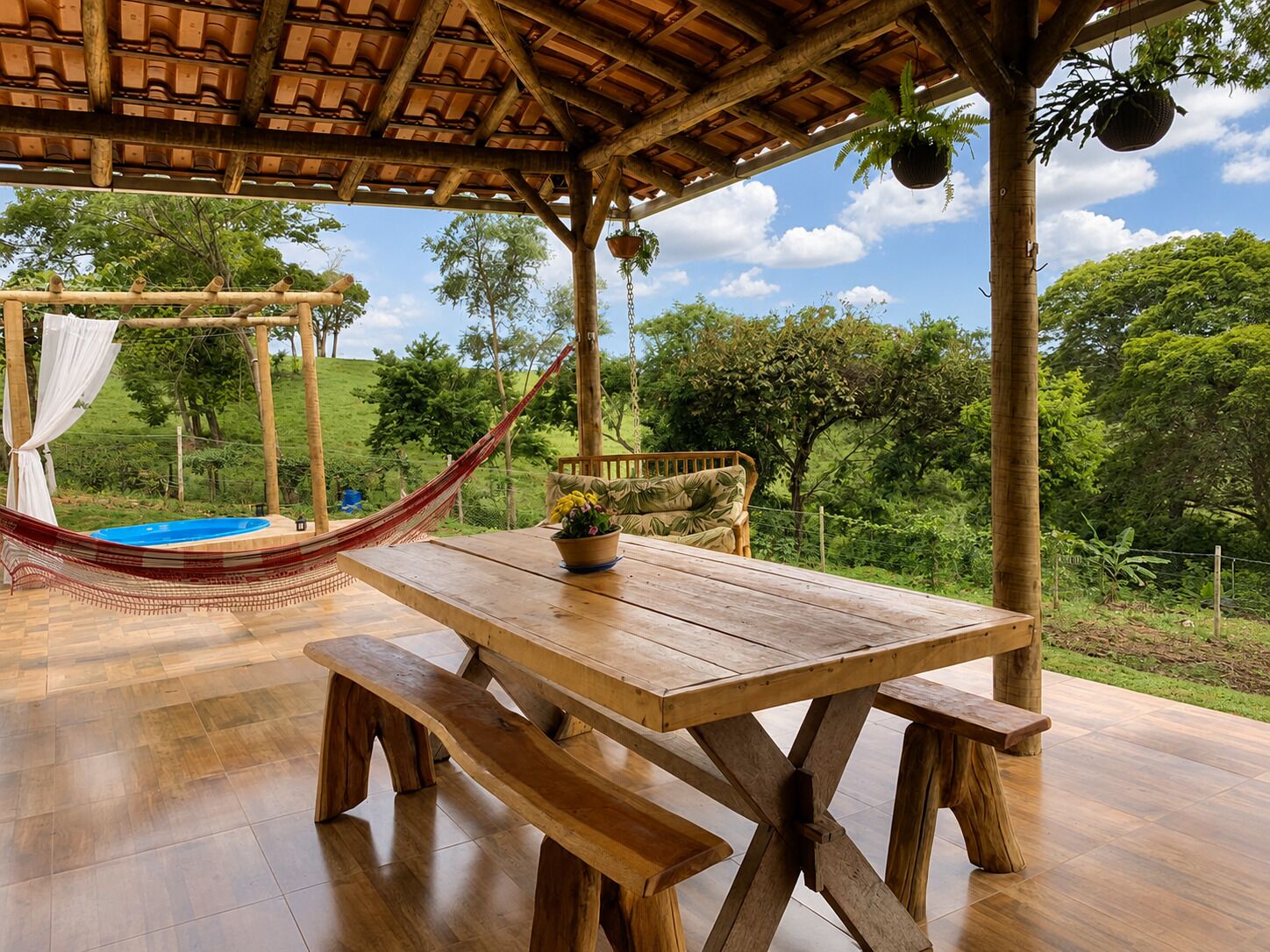 A wooden table with benches, a hammock, and a swing under a wooden pergola.