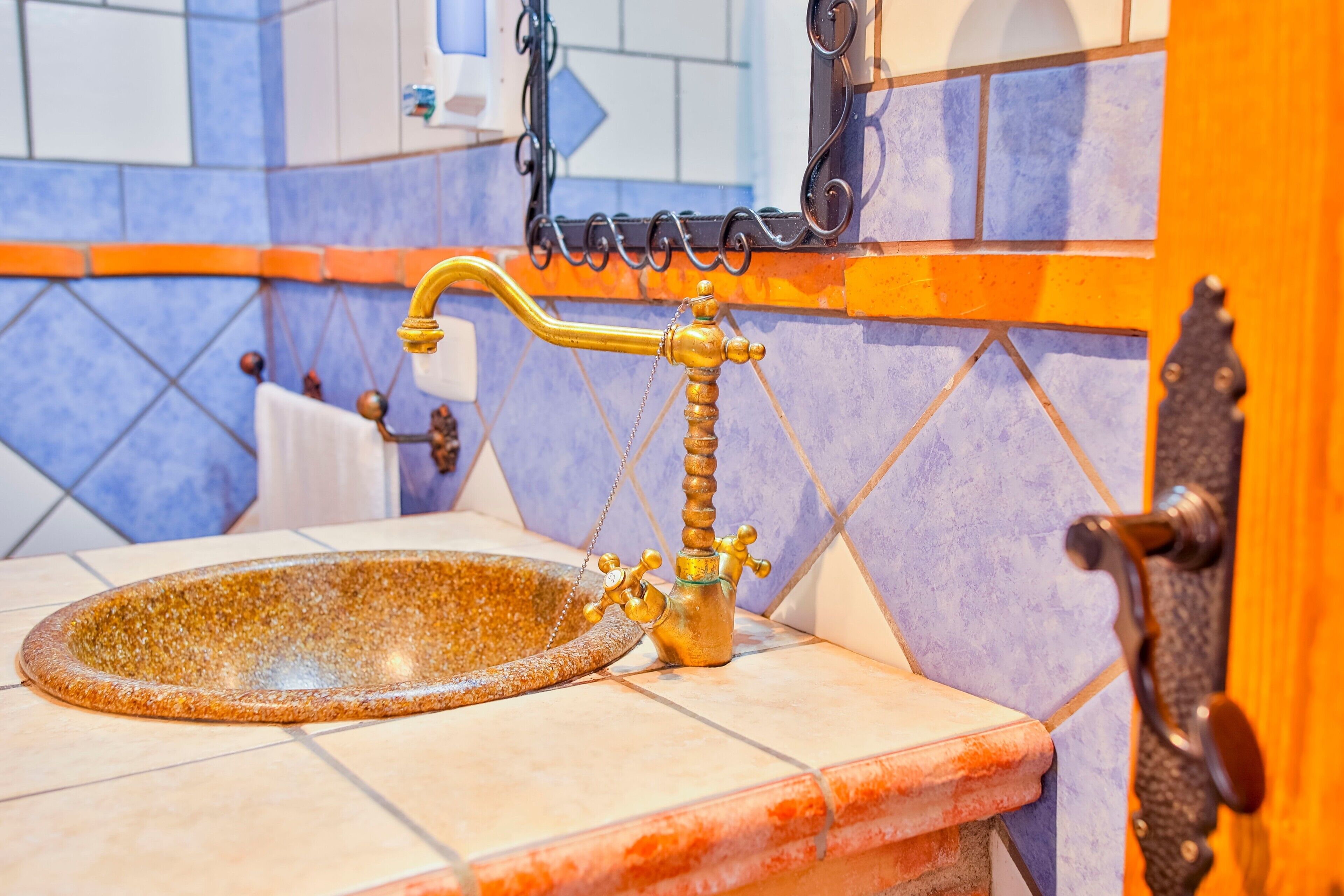 A bathroom with a vintage-style sink, a towel rack, and a mirror.