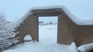 En snötäckt entré med en betongbåge som leder in till ett snöigt landskap.