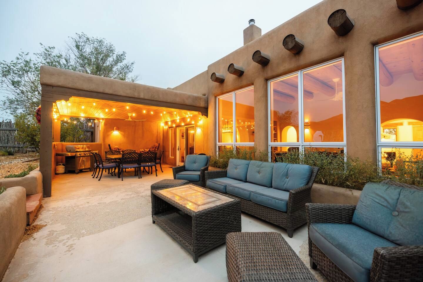 Un espace extérieur aménagé en terrasse, avec une table à manger, des chaises et un barbecue.