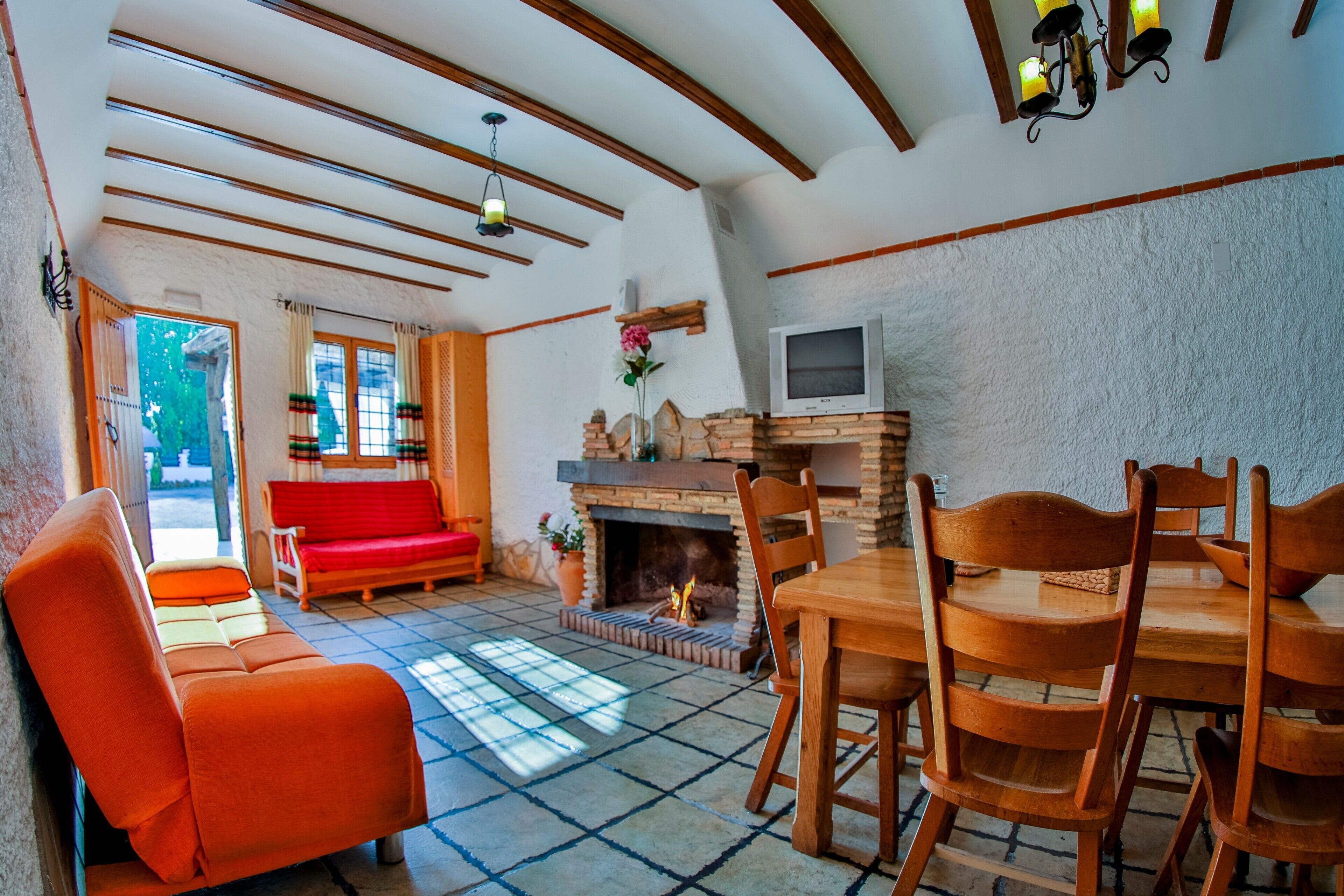 Una sala acogedora con chimenea, una mesa de comedor y un sofá.