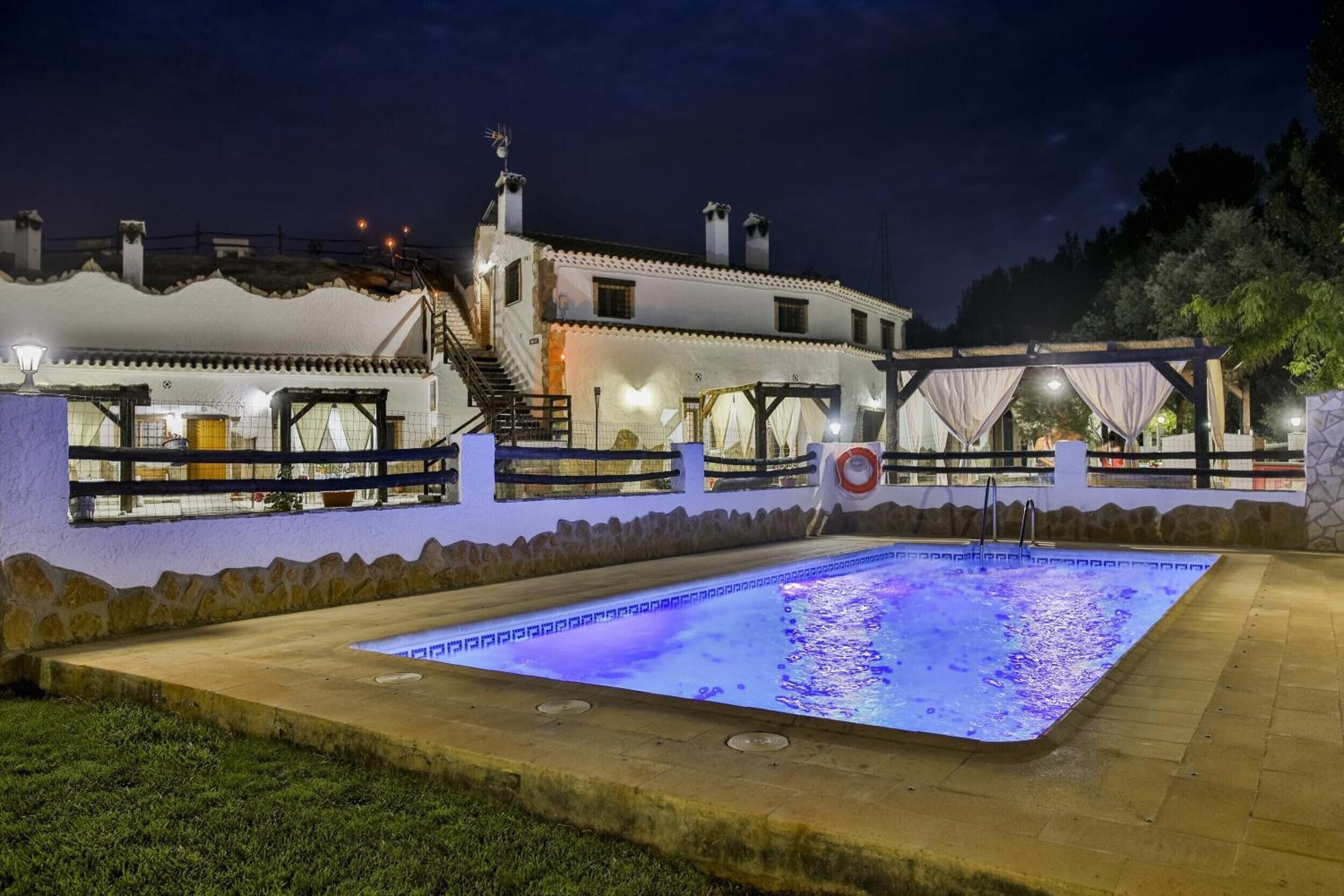 Un edificio con piscina, mobiliario exterior y una escalera que lleva a los pisos superiores.