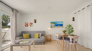 Un salon moderne comprenant un canapé, une table basse et un coin repas avec des chaises et une table.