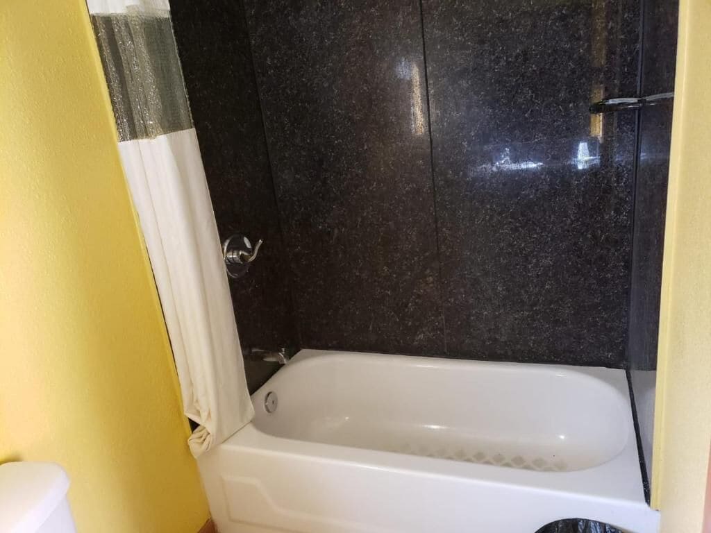 Un baño con bañera, inodoro y zona de ducha.