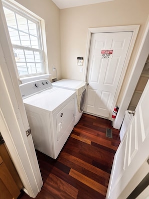 A laundry room with a washer and dryer, a restricted area sign, and a fire extinguisher.