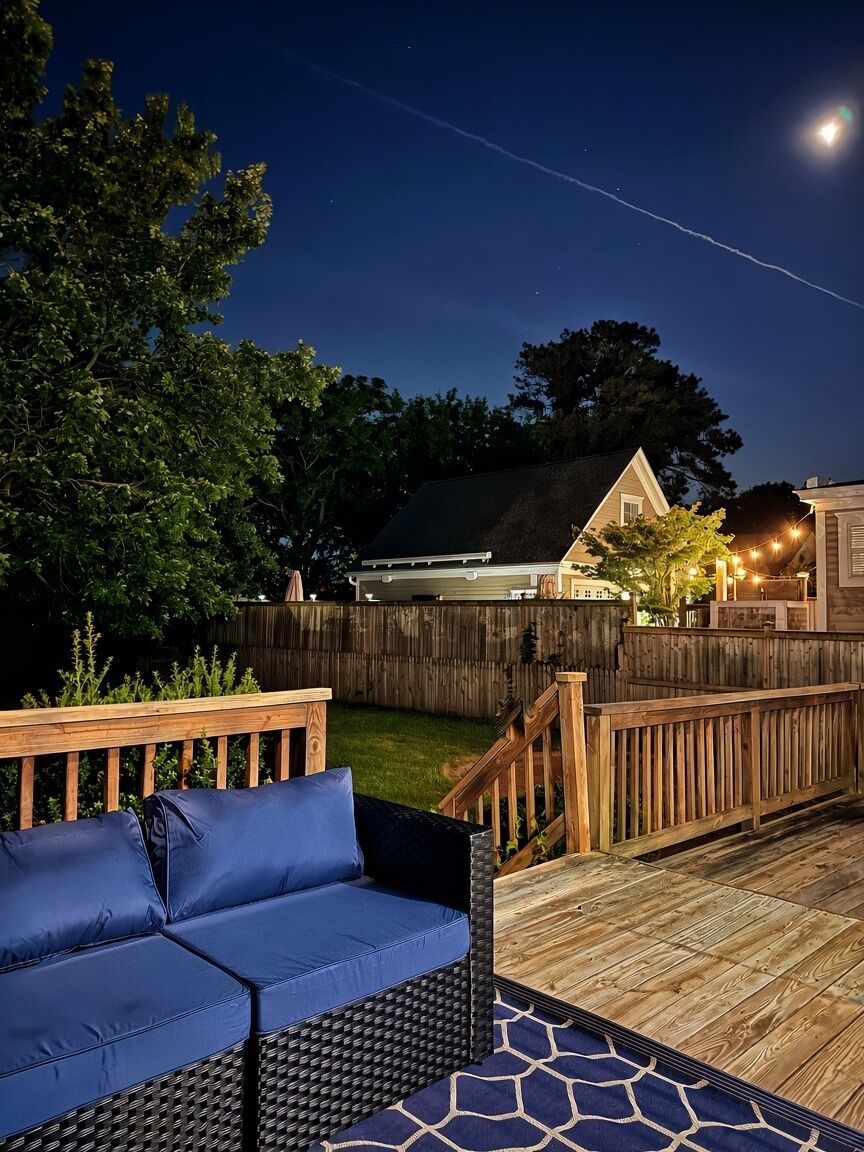 A wooden deck with a blue sofa and a patterned rug.
