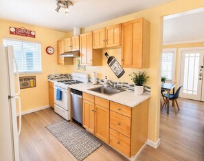 Una cocina con armarios de madera, estufa, fregadero y refrigerador.
