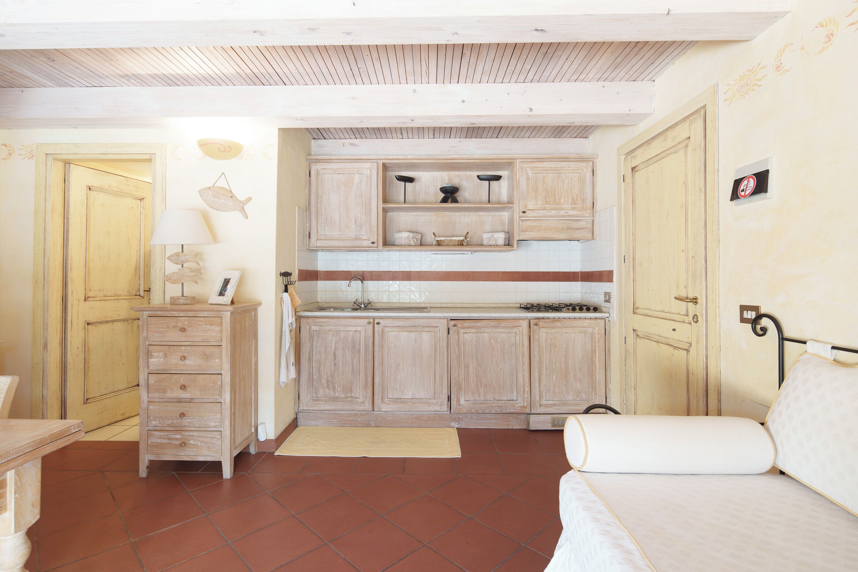 Una cucina compatta con mobili in legno, un fornello e un lavandino.
