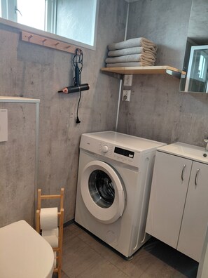 Een haardroger, handdoeken, zeep, toiletpapier