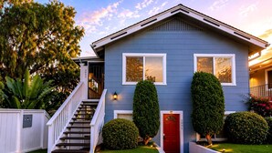 A two-story house with a red door, white trim, and a front staircase. - CasaViva Breeze 2BR w/ Sunset Views, Firepit & Backyard — Walk to Fun & Eats (San Diego)