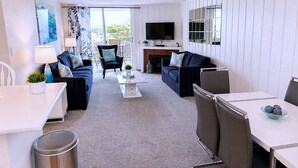 A modern living room with a sofa, armchairs, a coffee table, and a TV. - SolMar Vista 2BR/2BA Oceanview, Heated Pools, Hot Tubs & Steps to Beach (Oceanside)