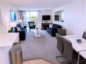 A modern living room with a sofa, armchairs, a coffee table, and a TV. - SolMar Vista 2BR/2BA Oceanview, Heated Pools, Hot Tubs & Steps to Beach (Oceanside)