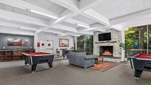 A spacious indoor area with a pool table, a sofa, a fireplace, and a bar area. - SolMar Vista 2BR/2BA Oceanview, Heated Pools, Hot Tubs & Steps to Beach (Oceanside)