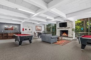A spacious indoor area with a pool table, a sofa, a fireplace, and a bar area. - SolMar Vista 2BR/2BA Oceanview, Heated Pools, Hot Tubs & Steps to Beach (Oceanside)