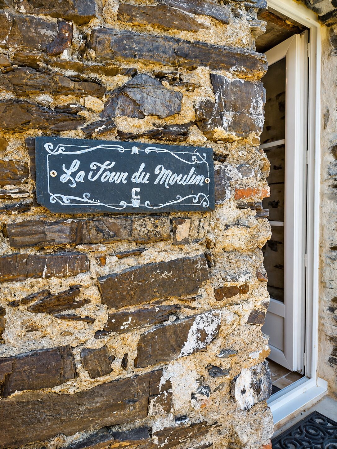 Um muro de pedra com uma placa que diz 'La Tour du Moulin'.