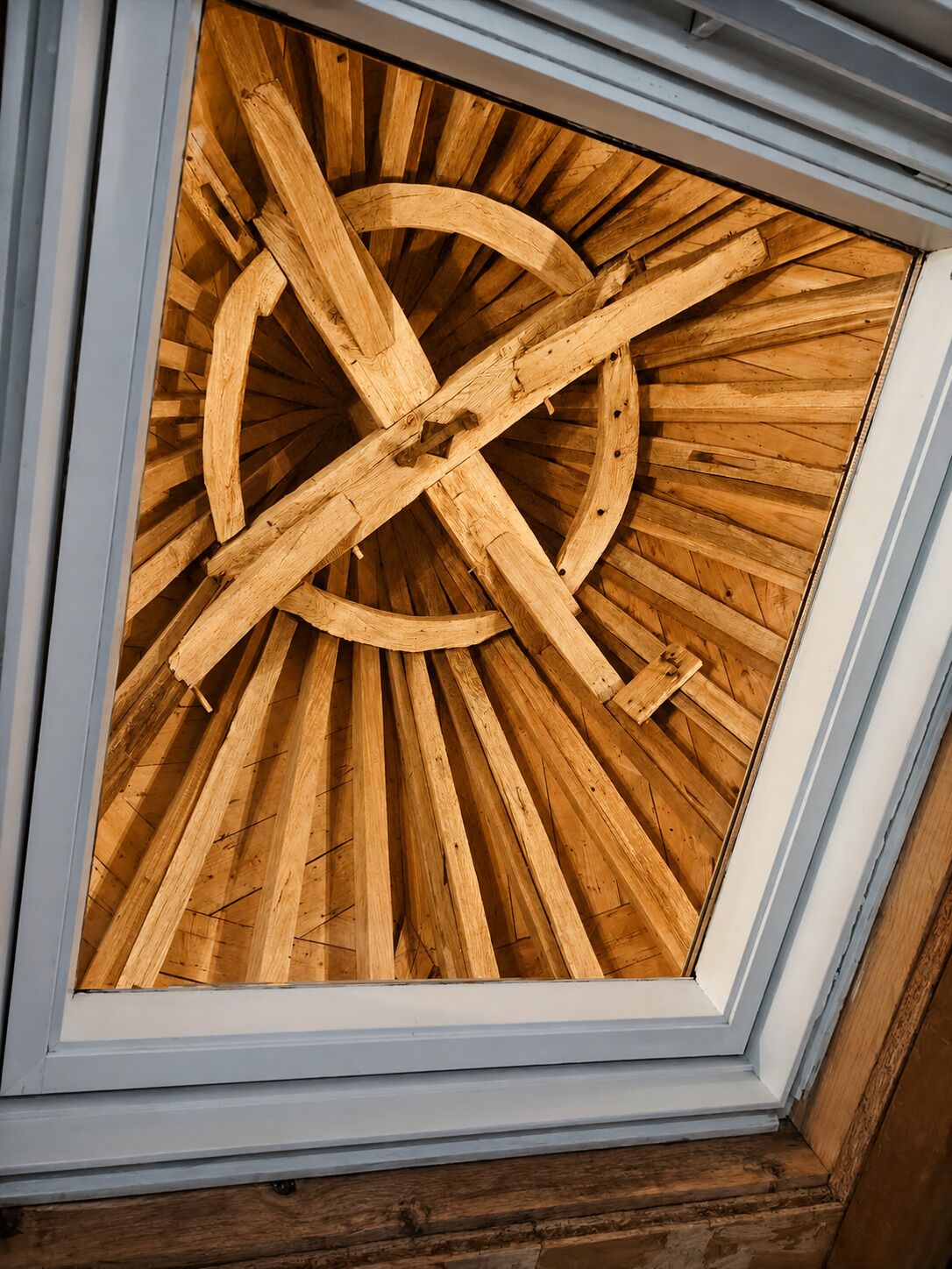 Un tragaluz con estructura de madera y diseño circular.