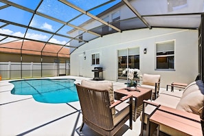 A sunlit outdoor patio with a swimming pool, wicker furniture, and a grill. - Upstay Contemporary Retreat w Pool, BBQ & Backyard (Davenport)
