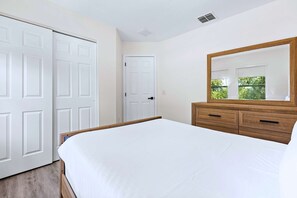 Ein Schlafzimmer mit einem Bett, einem Schminktisch und zwei Türen.