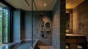 A modern bathroom with a glass-enclosed shower, a built-in sink, and a large mirror.