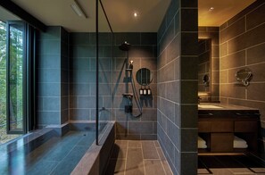 A modern bathroom with a glass-enclosed shower, a built-in sink, and a large mirror.