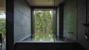 Une salle de bain moderne avec une douche en verre et une vue sur une forêt.
